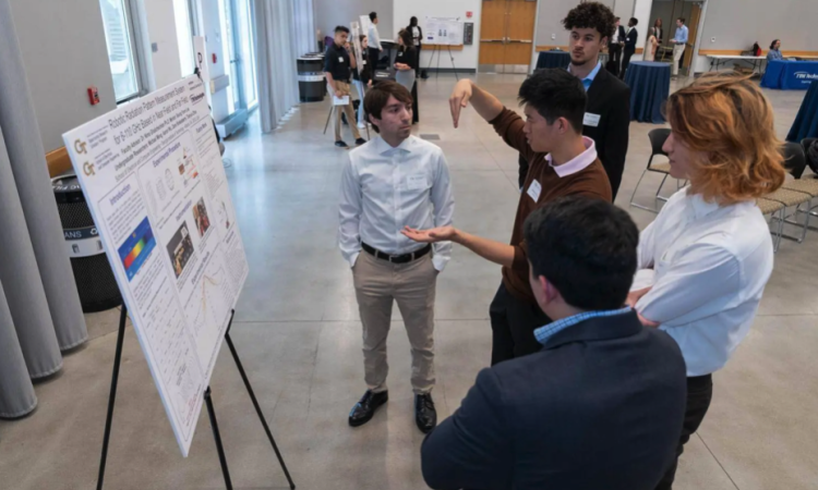 Photo of students displaying their research poster at this year's ECE Opportunity Research Scholars Symposium (ORS)