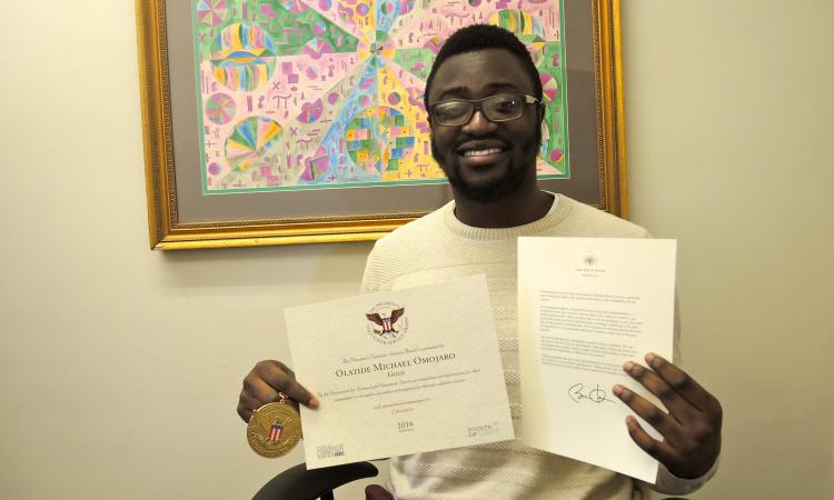 Olatide Omojaro, with his President's Volunteer Service Award.