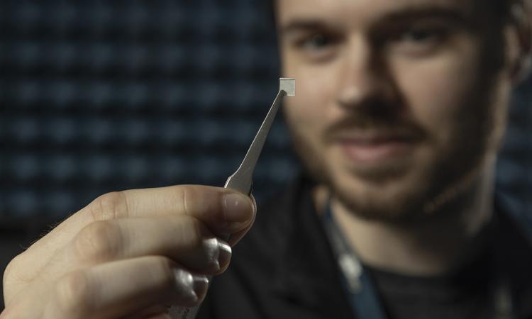 Research Scientist Connor Frost shows the electrical device patterns that capture radio frequency energy to alter the properties of the tiny structure. (Credit: Christopher Moore)